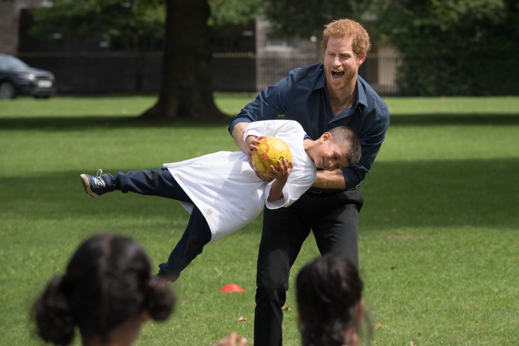Prince Harry Gives a Group of Kids a Good Rough and Tumble During a Charity Visit